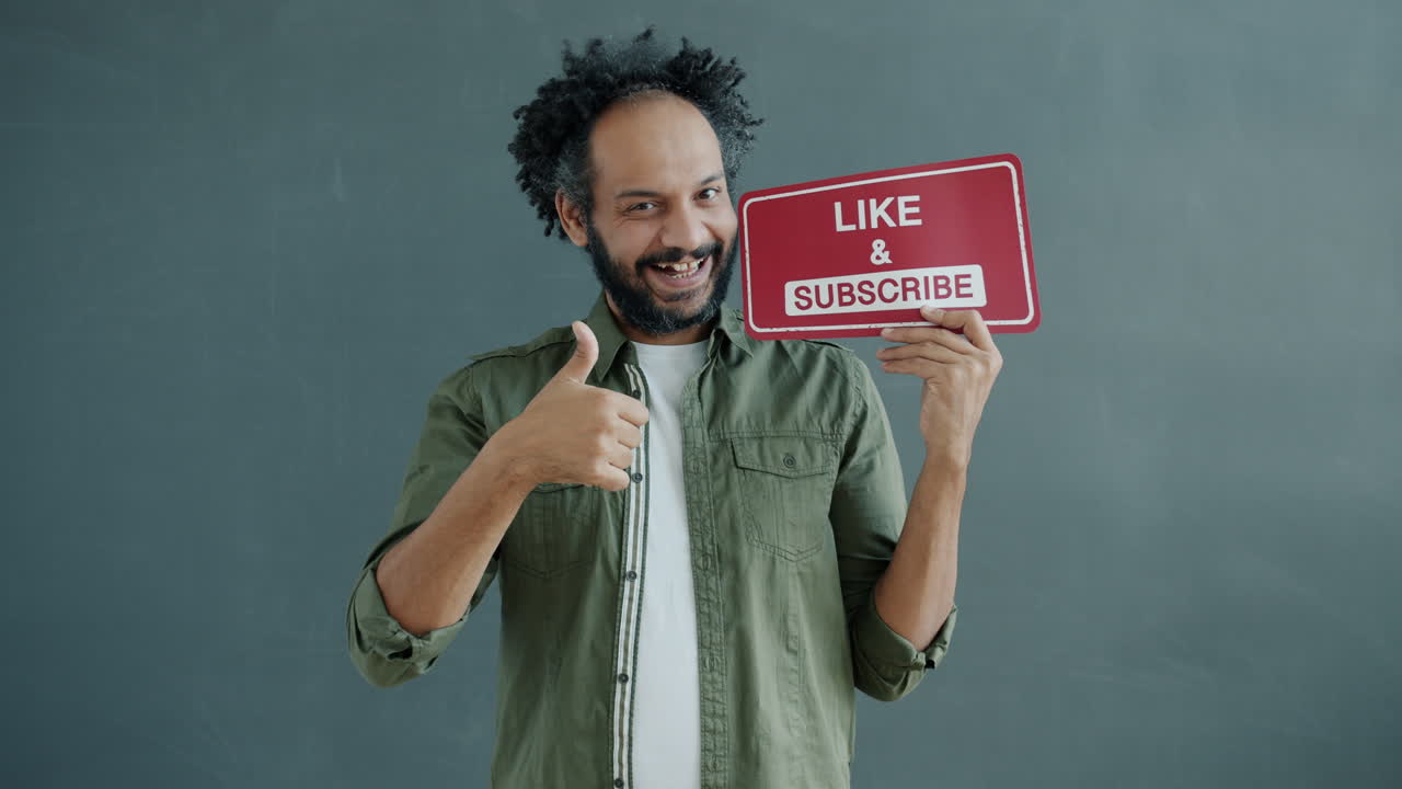 Uomo che regge un cartello con scritto 'Metti Mi Piace e Iscriviti'