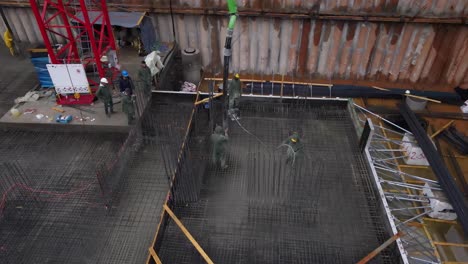 Aerial-view-of-construction-workers-laying-wet-cement-using-automatic-pump-machine