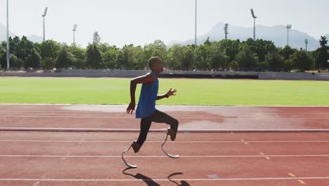 disabled mixed race man with prosthetic legs running on race track