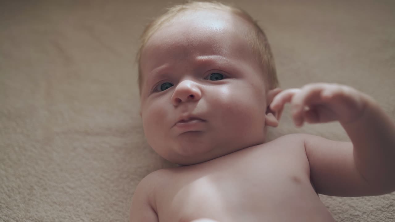 filho recém-nascido adorável com cabelos curtos e grandes olhos azuis