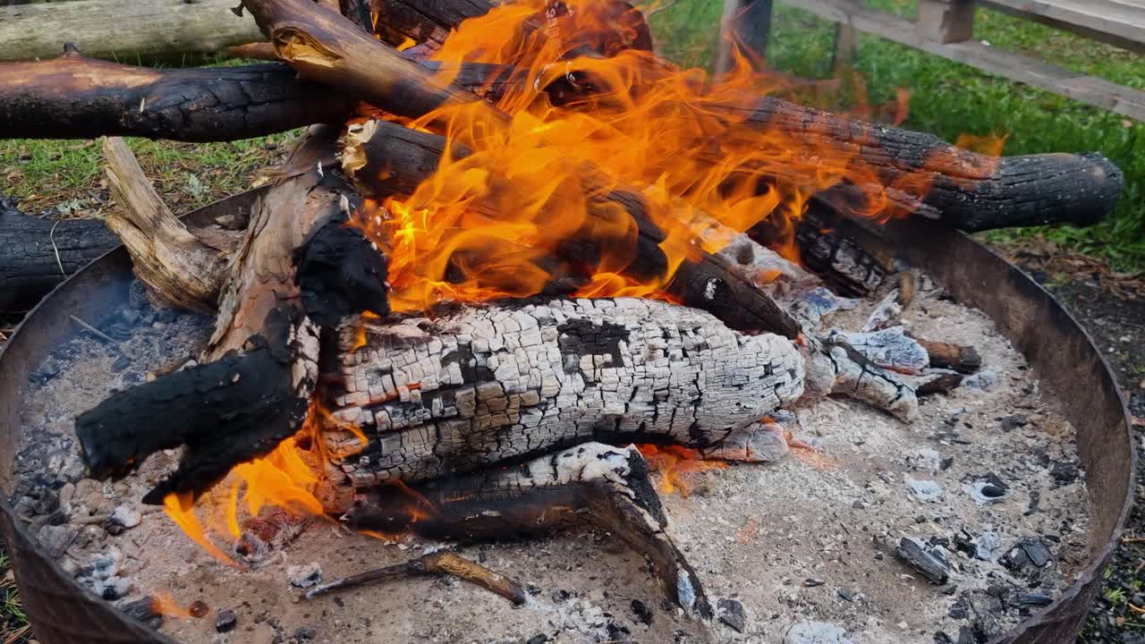 Crackling campfire in the cool air of Greece’s Vrontous mountains near Lailias, flames flicker and sizzle, glowing warmly in the dusk of the wild highlands