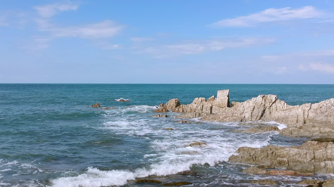 Le onde dell'oceano si schiantano sulla costa rocciosa
