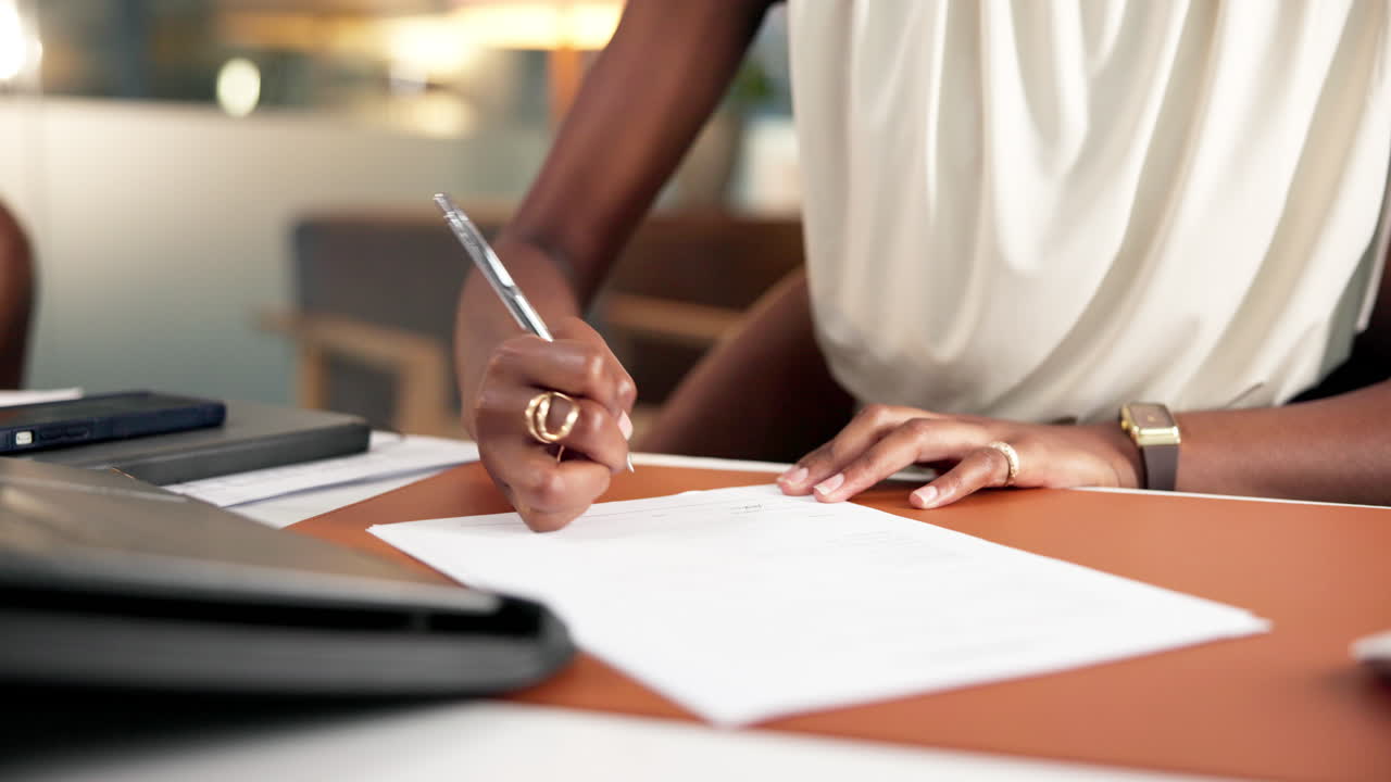 Close Up of Person Writing and Signing a Document at an Office Desk