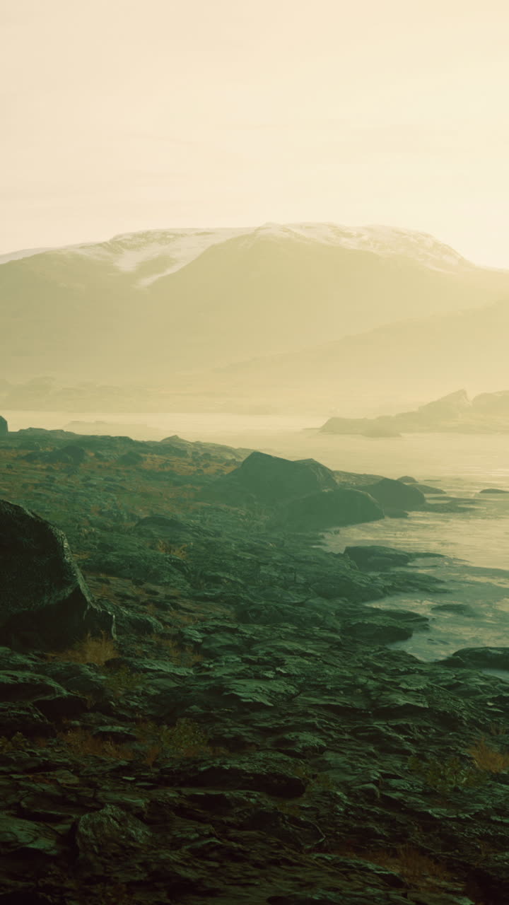 Majestic dawn breaks over rugged mountains reflecting in serene waters