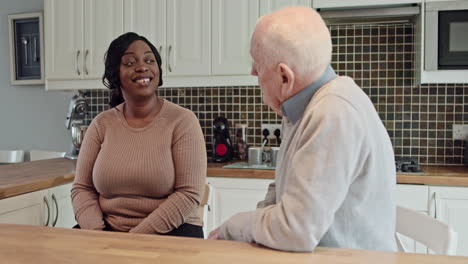caregiver and senior man in kitchen
