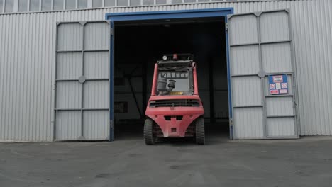 the big industrial forklift drives into the warehouse.