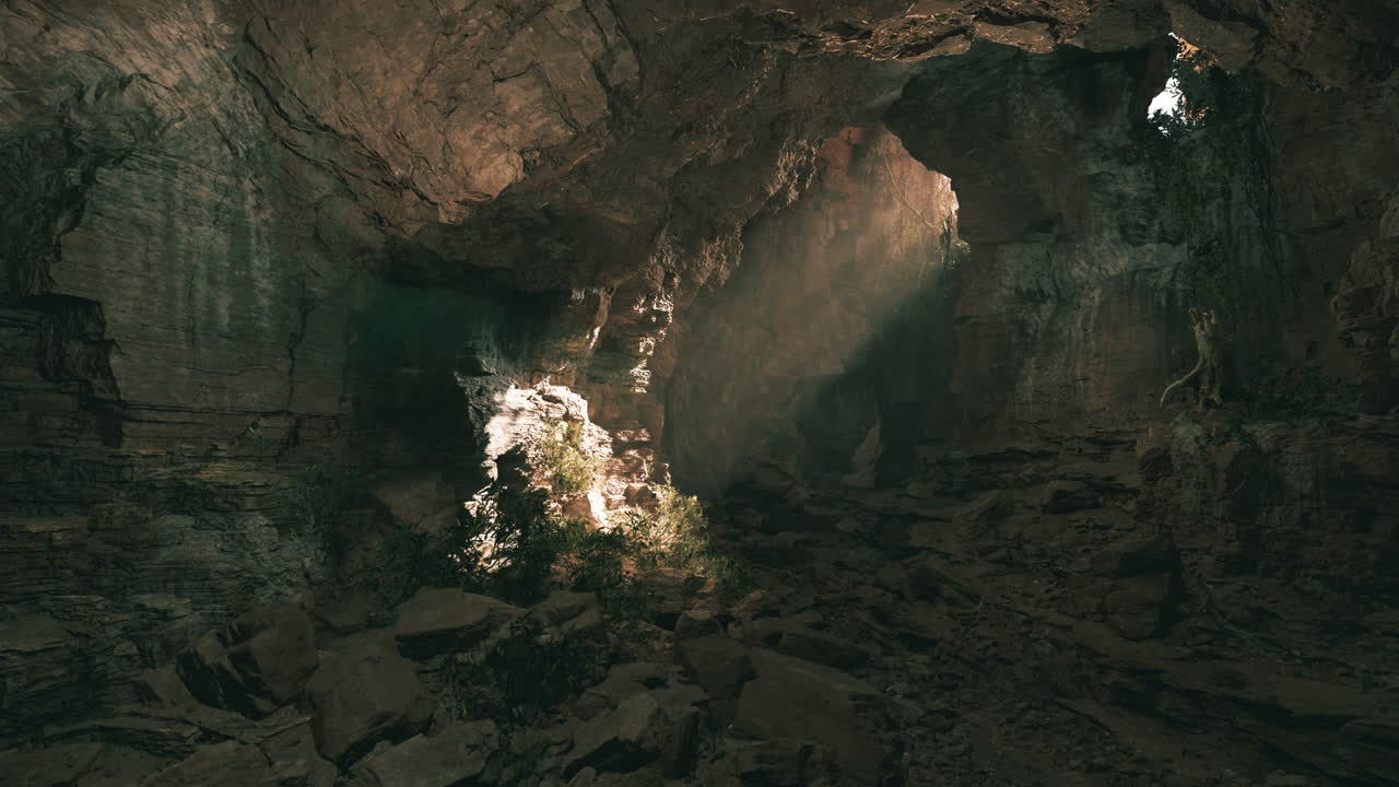 Raggi di sole illuminano una grotta con rocce e vegetazione in un ambiente naturale