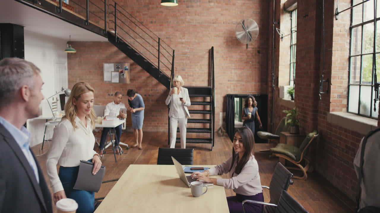 Crane shot in busy office open plan boardroom area