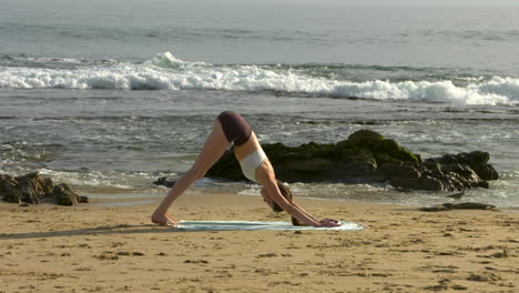 an attractive young woman practicing yoga on a beautiful california beach-1