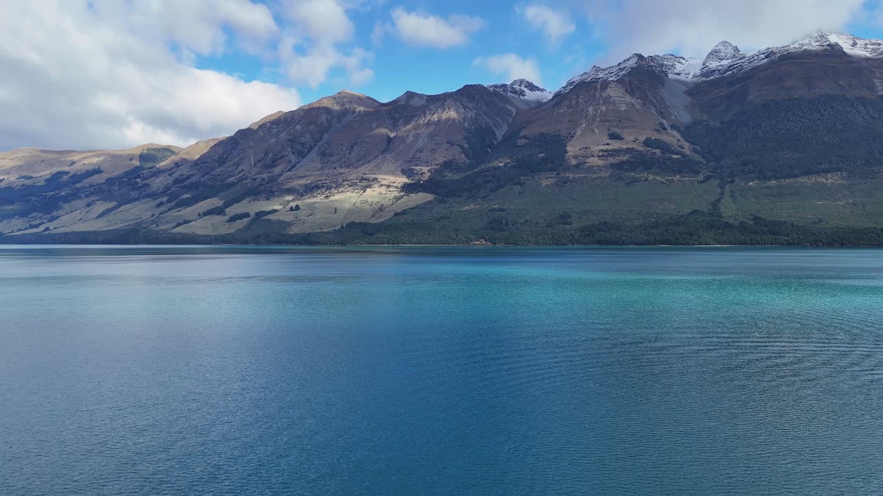 A tranquil scene of a lake with mountains in Glenorchy, New Zealand. Clear skies and calm waters create a peaceful atmosphere