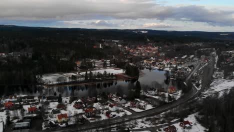 drone shot of a snowy landscape and a small village called kopparberg in sweden.