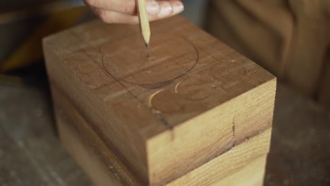 carpenter marking a circle onto wood for routing