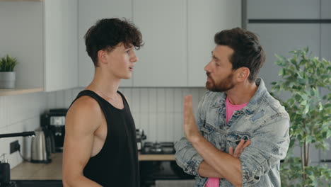argument between two young men in a kitchen