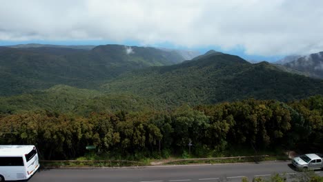 Vista-De-Pájaro-De-Un-Autobús-Blanco-Que-Recorre-La-Extensa-Vegetación-De-La-Sierra-De-La-Gomera