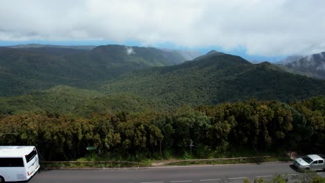 vista de pájaro de un autobús blanco que viaja a través de la amplia vegetación de la cordillera de la gomera