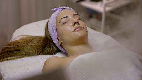 young woman relaxing during a facial spa treatment
