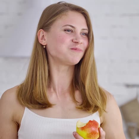 Beautiful young girl eats an apple