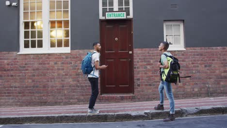 two mixed race male friends walking and looking for hostel in the street