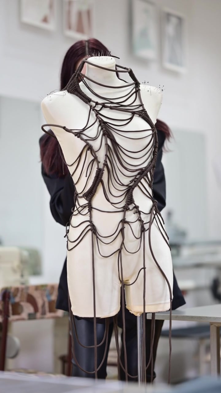 A designer working on a mannequin in a studio environment. Vertical