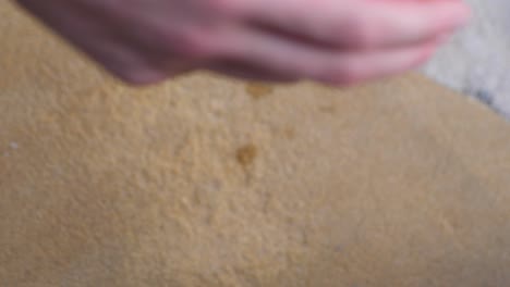 man's hand picks up a glass of citrus juice