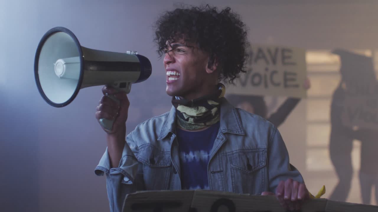 얼굴 마스크를 쓰고 시위 표지판을 들고 메가폰으로 소리를 지르는 다양한 그룹의 사람들