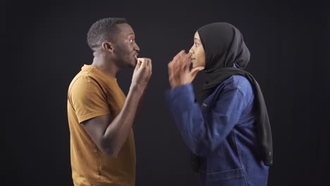 una infeliz pareja musulmana africana discutiendo y no escuchando el uno al otro.