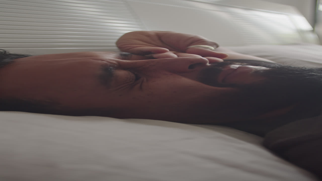 Young Woman Waking Up in Bed in Morning