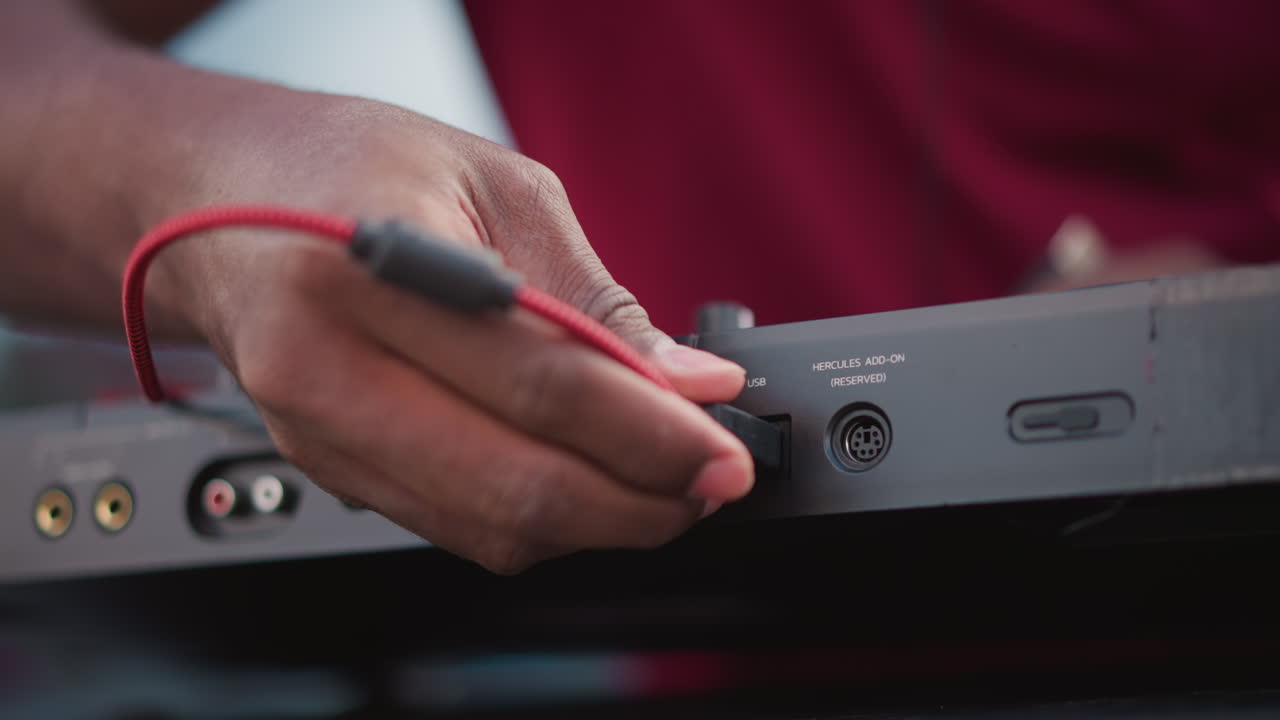 black DJ adjusting jack during soundcheck, tight closeups of fingers inserting red cable into DIN socket, quick patch swaps and channel checks, ambient crowd murmur and street set tension before drop