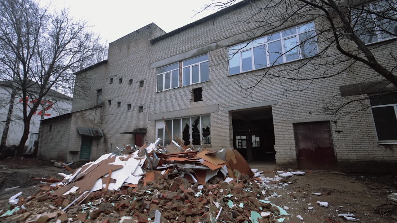 Pile of debris outdoors is under the old ruined buildings. Approaching the large doorway with no doors into the premise.