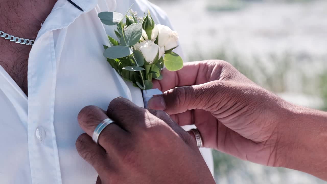 O noivo tem flores presas na sua camisa antes da cerimônia de casamento