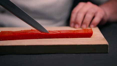 Chef-cuts-red-jelly-on-wooden-cutting-table