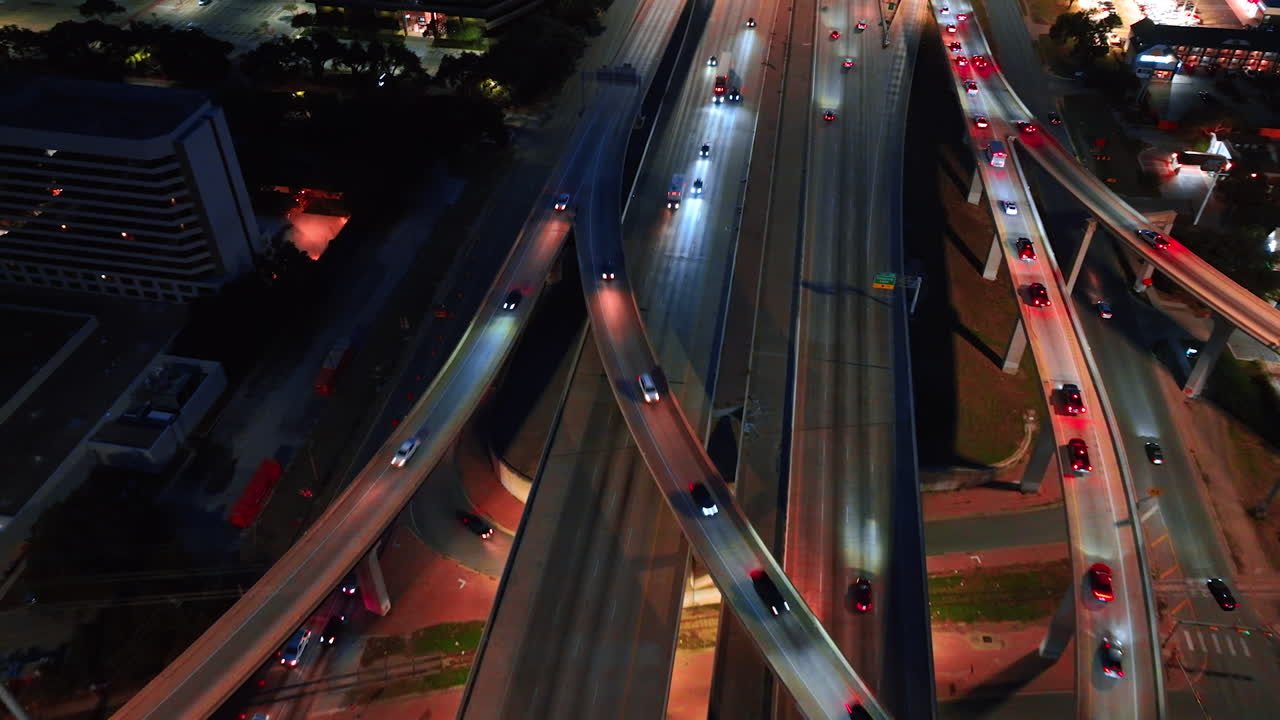 Strada e cavalletti nella città moderna con numerose auto. Traffico vivace di notte. Vista aerea