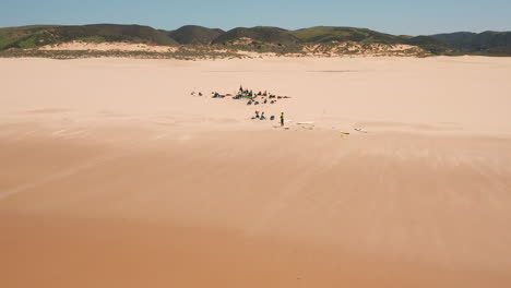 Aerial:-Surfing-the-beach-of-Bordeira-in-the-Algarve,-Portugal