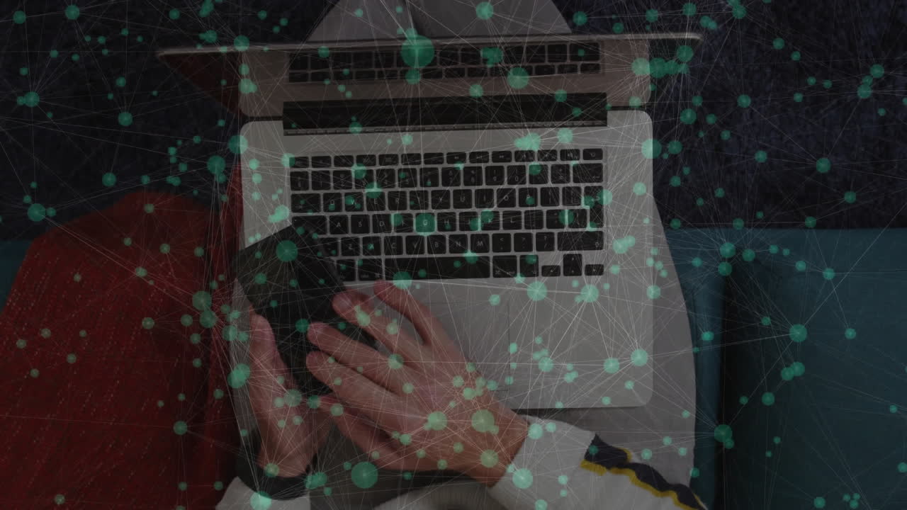 Man using smartphone and laptop in tech scene, displaying animated green data network overlay