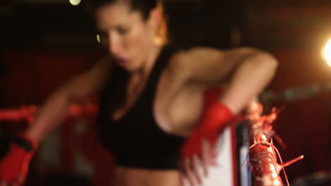una boxeadora cansada de pie en el ring