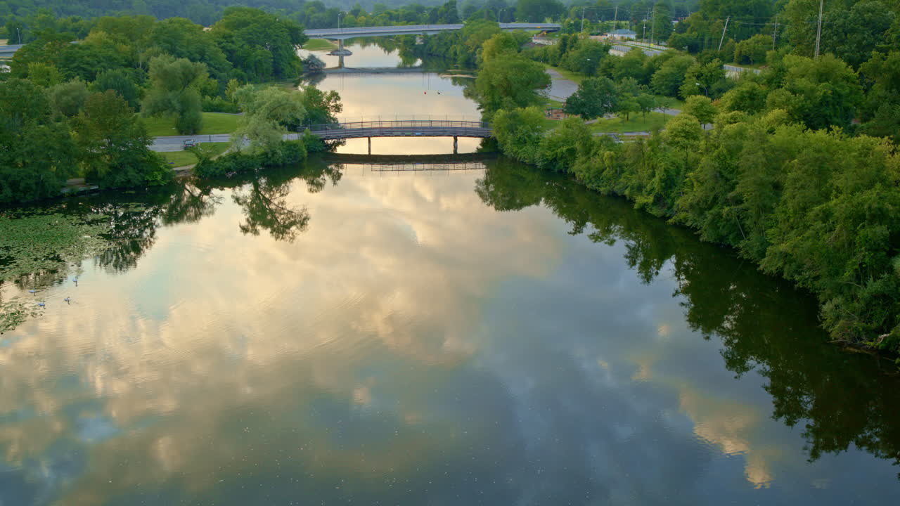 Aerial footage of a drone floating slowly over the Huron River in Ann Arbor, Michigan, in summer.