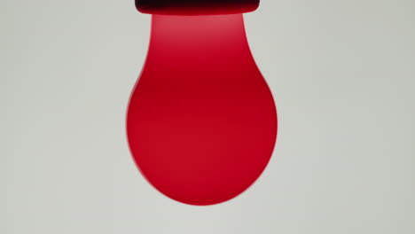 The-red-incandescent-lamp-is-turned-on-on-a-white-background-1