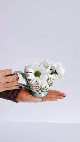 floral mug with white flowers in hand