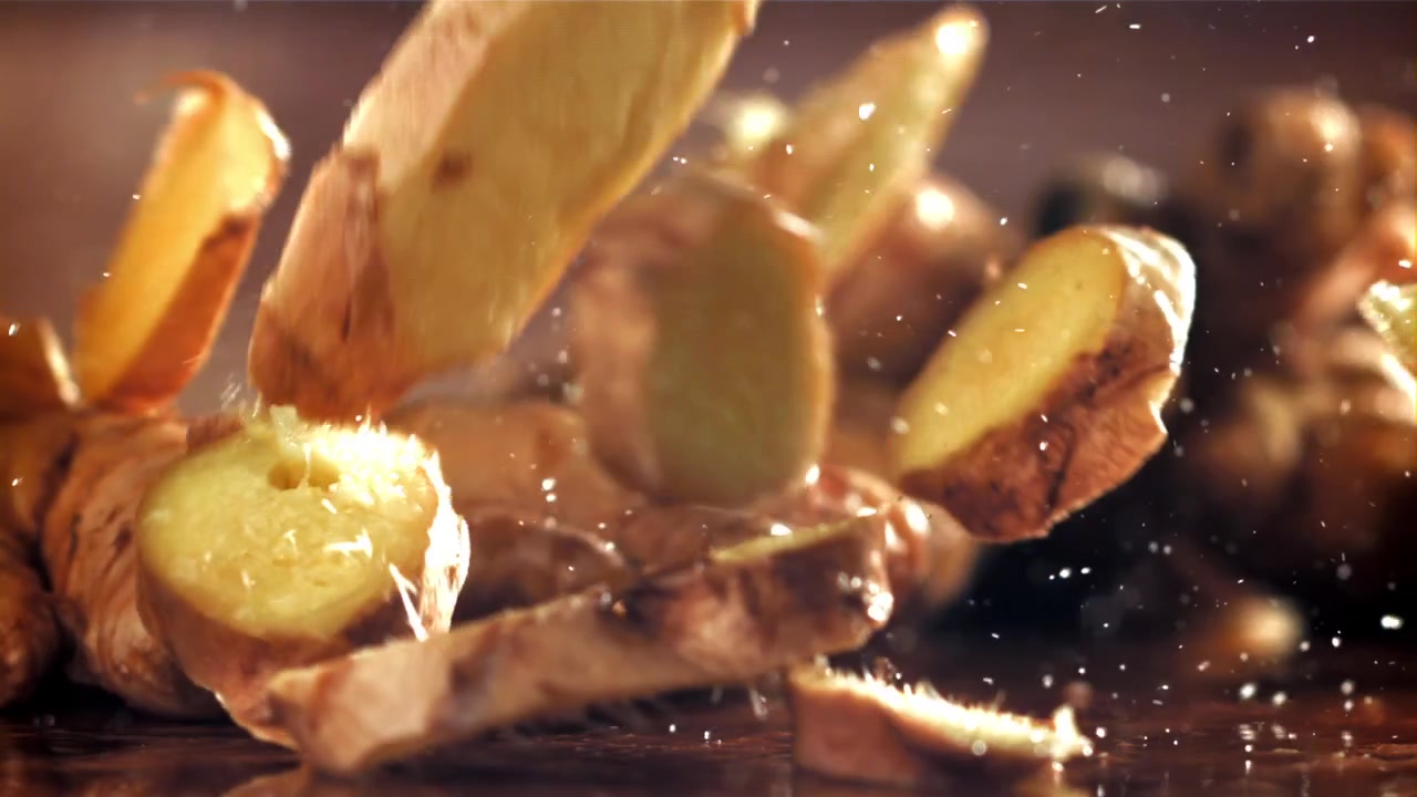 Fresh Ginger Slices Falling and Splashing in Slow Motion