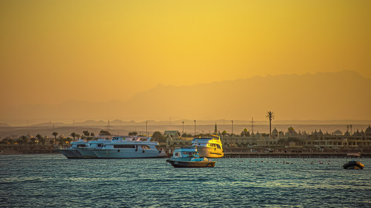 brumoso atardecer dorado con barcos en el puerto del mar rojo - lapso de tiempo