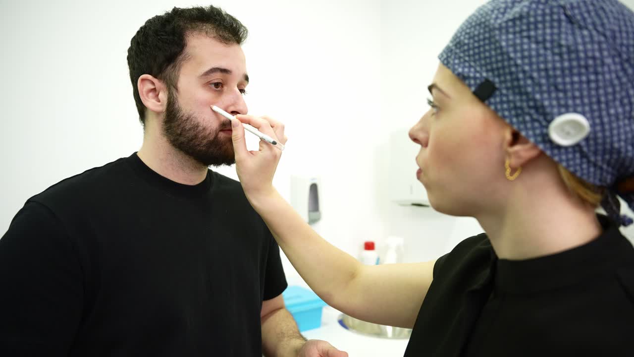 Medical Professional Marks Man's Nose During Consultation in Clinic