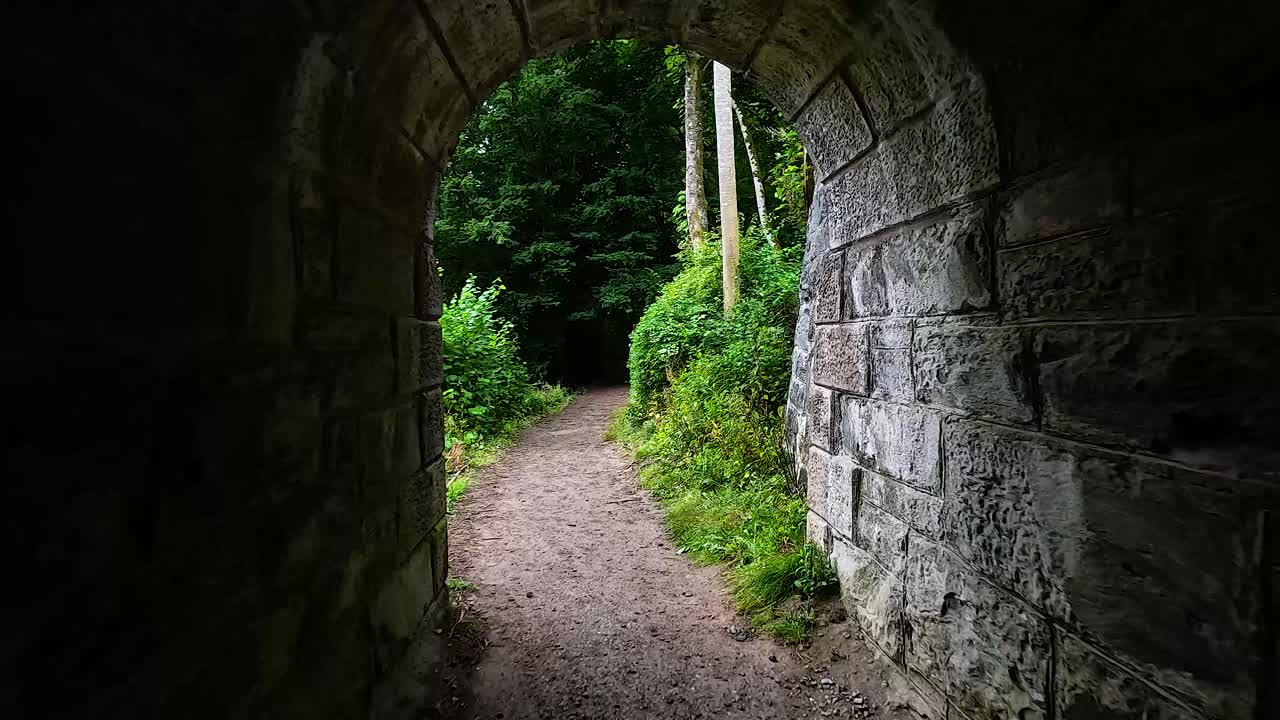 돌로 된 터널 을 통과 하여 울창 한 숲 으로 들어가는 길