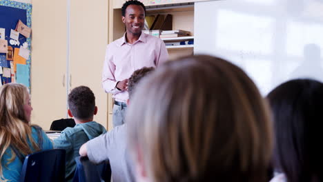 un maestro habla con los alumnos en la lección de la escuela primaria