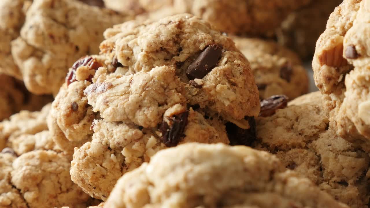 Biscotti d'avena serviti su un piatto con DOF ridotto, filmato panoramico UHD 4K 2160p 30fps - Pila di biscotti con gocce di cioccolato fatti in casa, panoramica lenta ravvicinata, video UltraHD 3840X2160