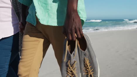 una pareja mayor caminando por la playa.