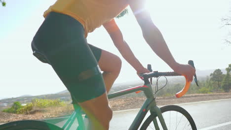 Against-the-backdrop-of-an-early-morning,-a-man-rides-his-road-bike-for-outdoor-exercise-on-an-empty-road.-The-slow-motion-perspective-enhances-the-thrill-of-extreme-sports