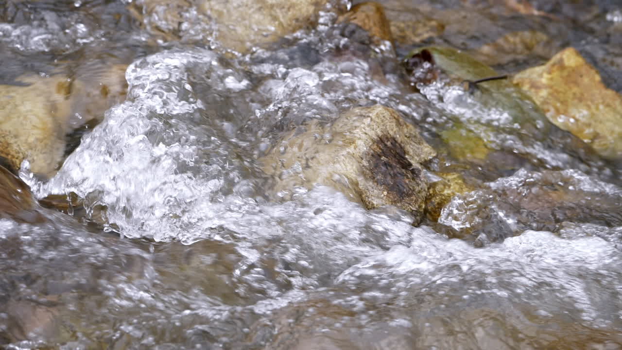 슬로우 모션으로 흐르는 풍부한 강 돌 바위를 통해 흐르는 맑은 스트림