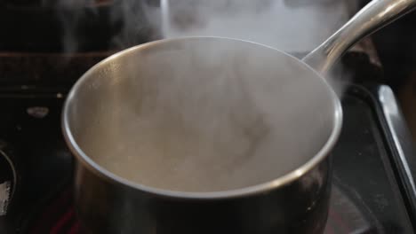 boiling water in a stainless steel pot - close up shot