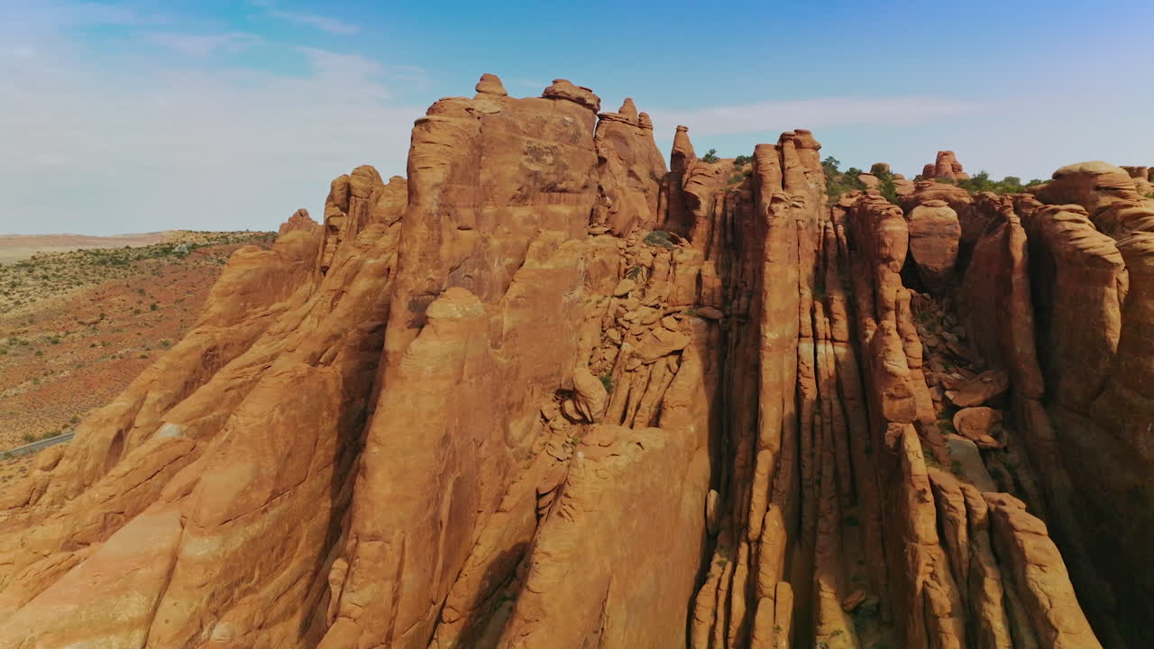 Volando tra montagne dalle forme bizzarre con poca vegetazione in cima. Rocce spettacolari sullo sfondo di un cielo azzurro.