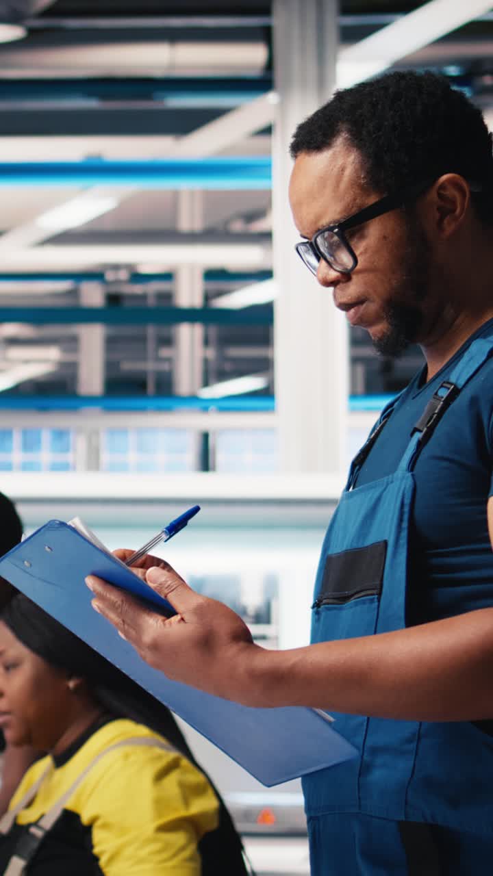Vertical Video Black engineer in photovoltaics factory reviews performance of solar panels